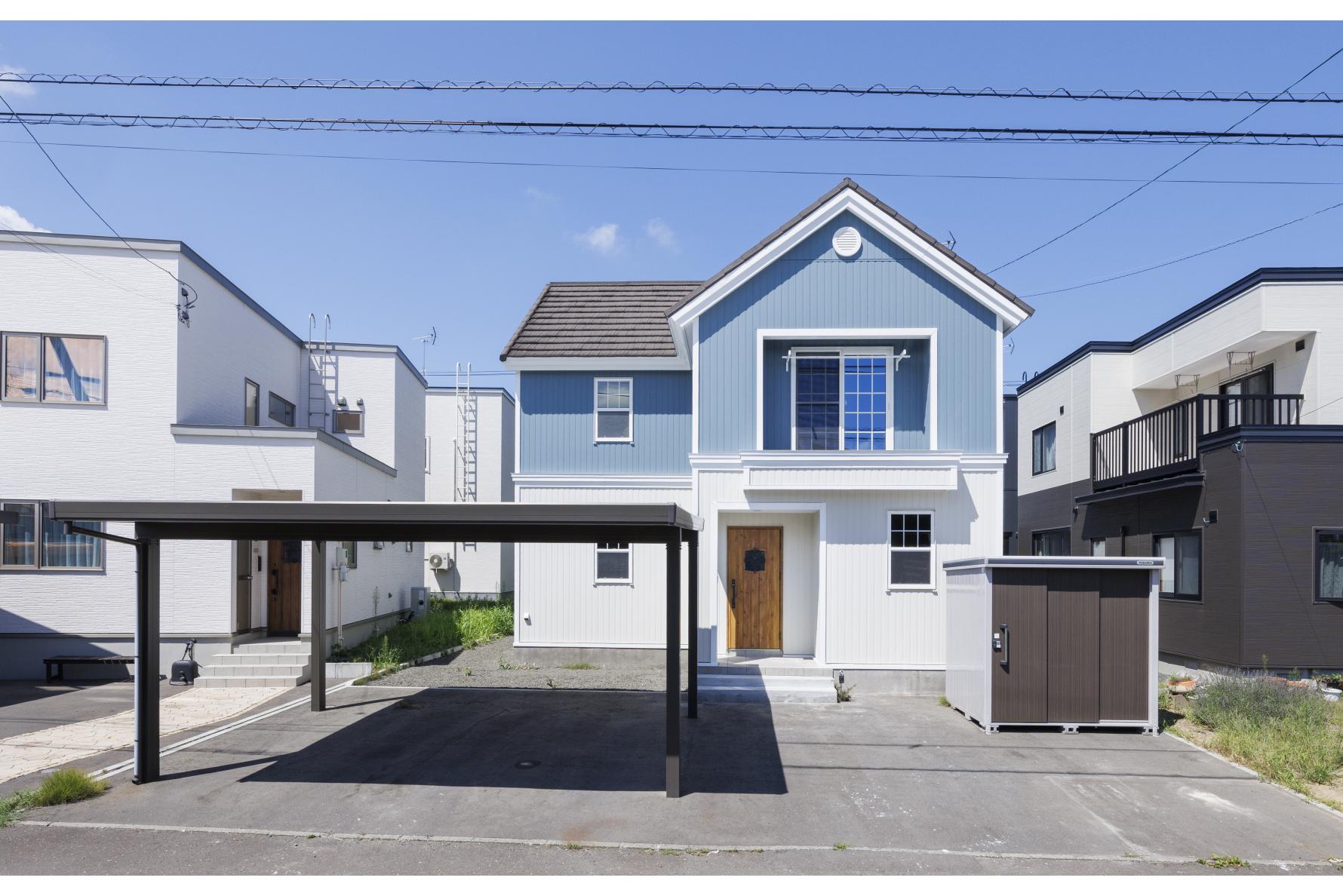 輸入住宅らしさはそのままに、外壁をブルーとホワイトに貼り分け、北欧調の外観へと一新。